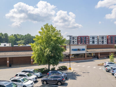 A parking lot with cars parked in front of a building.