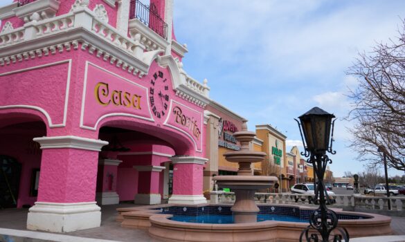 Pink building with a clock and fountain.