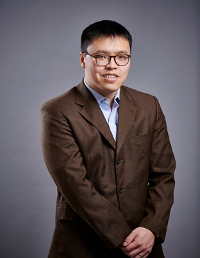 A man in a brown suit and glasses.